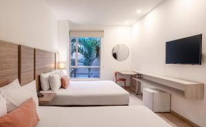 a hotel room with two beds and a flat screen tv at Hotel MS Pacifico Chipichape in Cali