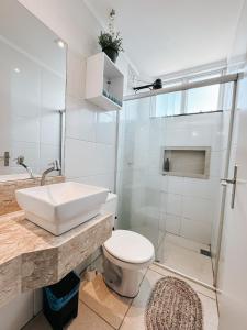 a bathroom with a sink and a toilet and a shower at Apto em condomínio, vista lagoa in Três Lagoas