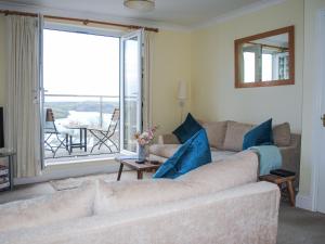 Una sala de estar con un sofá y una ventana grande. en 4 Lyndhurst, en Salcombe
