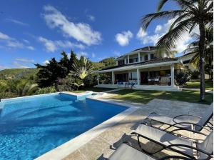 a swimming pool in front of a house at Villa with Stunning Ocean View, Infinity pool in Las Terrenas