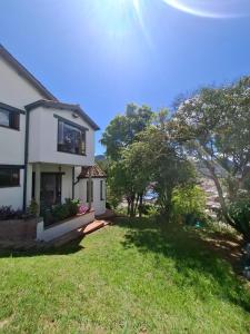 a white house with a yard with grass and trees at House Life in La Calera