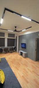 a room with a tv and a table and chairs at The Loft - Male Only in Chennai