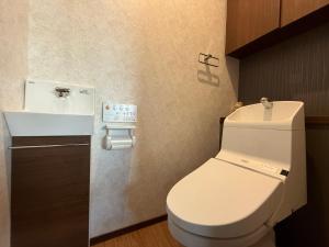 Un baño con un inodoro blanco y un lavabo. en MFR伊勢志摩hanare別荘 ペット可, en Toba 25 fotos más