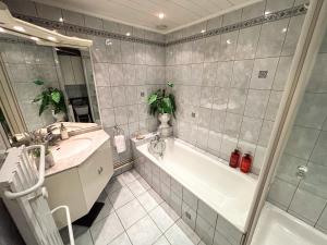 a bathroom with a tub and a sink at Le Green Field Lodge - Parking Gratuit - Standing - Centre Ville - Commerces à Proximité in Lingolsheim