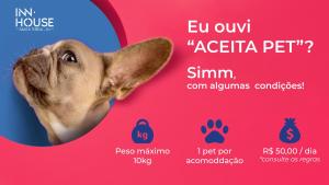 un chien rayant d'un signe avec une photo dans l'établissement Inn House Santa Teresa, à Rio de Janeiro
