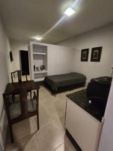 ein Wohnzimmer mit einem Bett und einem Schreibtisch. in der Unterkunft Los Cedros 43 in Salta