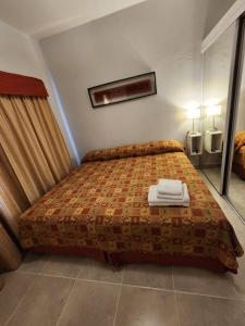 ein Schlafzimmer mit einem Bett mit zwei Handtüchern darauf in der Unterkunft Los Cedros 43 in Salta