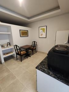 ein Wohnzimmer mit einem Tisch, einem Tisch und Stühlen in der Unterkunft Los Cedros 43 in Salta