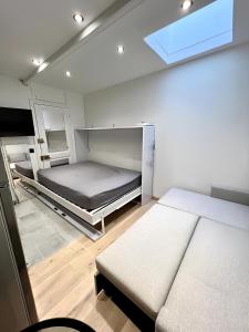 une petite chambre avec deux lits et une fenêtre dans l'établissement Appartement, à Neuilly-sur-Seine