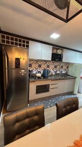 a kitchen with a stainless steel refrigerator and a counter at Apartamento Vista Mar - Área de Lazer - Poucos Minutos do Mar in Itapema