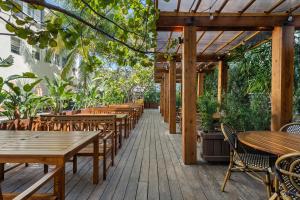an outdoor patio with wooden tables and chairs at Global Luxury Suites at The Apex Miami in Miami Beach