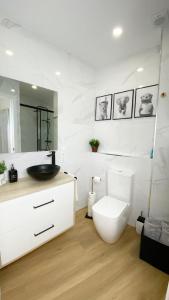 a white bathroom with a toilet and a sink at Gallaecia Dúplex in Arzúa +63 photos