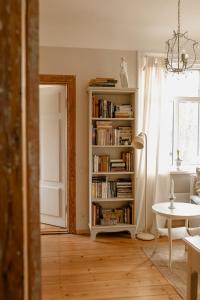 a living room with a book shelf filled with books at Vēsturiska privātmāja Ogres centrā in Ogre +30 photos