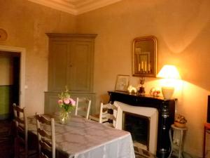 ein Esszimmer mit einem Tisch und einem Kamin in der Unterkunft Les Deux Tours in Brignon