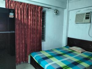 Un dormitorio con una cama y una cortina roja. en Cool sleep family rent in dhaka, en Dhaka