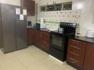 a kitchen with a black stove and a refrigerator at Suzie's Nest in Lilongwe