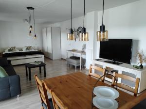 een woonkamer met een tafel en een woonkamer met een tv bij Ferienwohnung Bühlingen in Rottweil