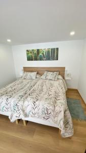 a bedroom with a large bed in a room at Gallaecia Dúplex in Arzúa