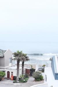 a house with palm trees and the ocean in the background at 4on Pebbles Holiday Home in Swakopmund