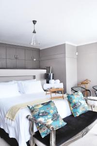 a bedroom with a large bed with white sheets and pillows at 4on Pebbles Holiday Home in Swakopmund