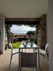 a table and chairs in a room with a stone wall at Porto San Paolo Nature Apartment in Porto San Paolo