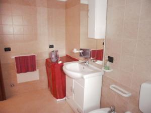 a bathroom with a white sink and a red refrigerator at appartamento Lucia in Tricase