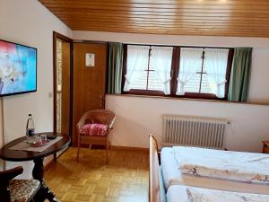 a small room with a bed and a table and a table sidx sidx at Pension Schlossbergblick in Simonswald