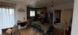 a kitchen and living room with a table and a refrigerator at Les Villas KAZEN in La Plaine des Cafres