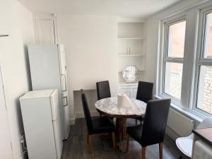 a kitchen with a table and chairs and a refrigerator at Serene Suite Rooms in Southampton