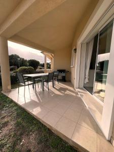 a patio with a table and chairs on a house at Villa Résidence San Martinu Sainte Lucie De Porto Vecchio in Zonza