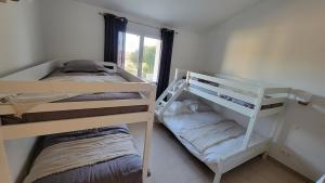 two bunk beds in a room with a window at Villa Résidence San Martinu Sainte Lucie De Porto Vecchio in Zonza