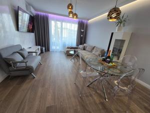 un soggiorno con un divano e un tavolo di vetro di REKO apartament z basenem i SPA tuż przy plaży a Rewal Altre 24 foto