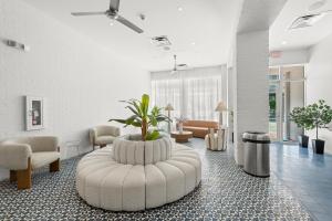 a lobby with a large white waiting room with a plant at Global Luxury Suites at The Apex Miami in Miami Beach