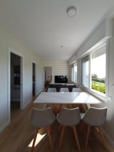 una sala de estar con una mesa y sillas en Villa Varela, en Hío