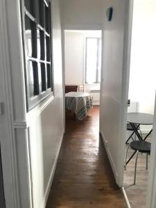 einen Flur, der zu einem Zimmer mit einem Tisch und einem Fenster führt in der Unterkunft Appartement confortable à Saint-Jean-de-Luz 45 m² avec cheminée in Saint-Jean-de-Luz