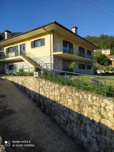 a building with a stone wall in front of it at BellaVista Alojamento in Arouca