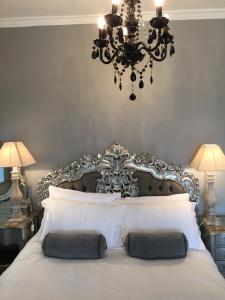 a bedroom with a large white bed with a chandelier at The White House Hotel in Newquay