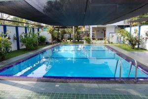 een zwembad met blauw water in een gebouw bij Orchid Villa in Negombo