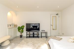 a white bedroom with a bed and a fireplace at Luxury Studio with Free Parking in Nottingham