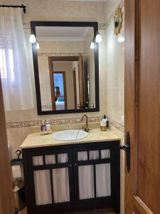 a bathroom with a sink and a mirror at El mirador de El Bosque in El Bosque +21 photos