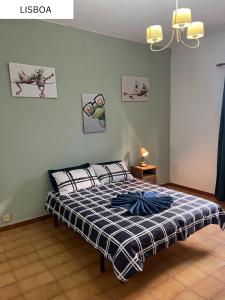 大加那利岛拉斯帕尔马斯Coliving Villa El Gago的卧室里有一张床，床上铺着蓝白相间的毯子
