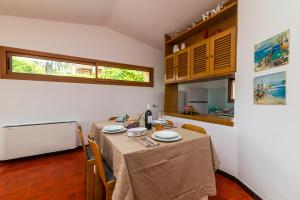 a dining room with a table and a kitchen at House Bados beach in Olbia