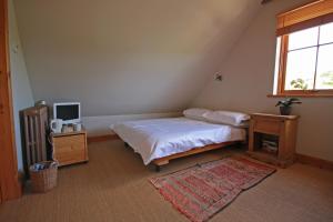 
a bedroom with a bed and a desk at Netherton Farm B&B in Culbokie
