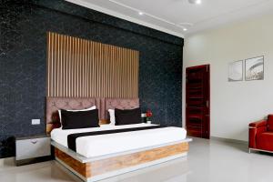 1 dormitorio con 1 cama grande y pared negra en Hotel O BGM, en Neemrana