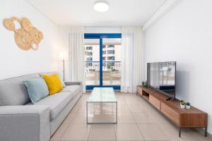 a living room with a couch and a tv at ApartUP Patacona Iconic II in Valencia