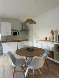 a kitchen with a wooden table and white chairs at Apartamentos COVARRUBIAS in Covarrubias