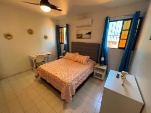 une chambre avec un lit et une table et deux fenêtres dans l'établissement Casa Corona Plaza, à Santiago de los Caballeros