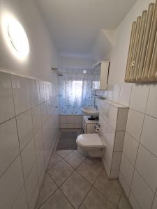a white bathroom with a toilet and a sink at Gäste Unterkunft 2 in Mönchengladbach