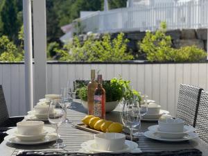a table with plates and glasses and a bottle of wine at No7 Risør in Risør
