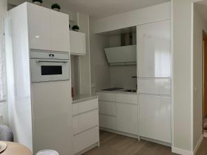 a white kitchen with white cabinets and an oven at Apartamento Boutique Arquera Golf III in Llanes